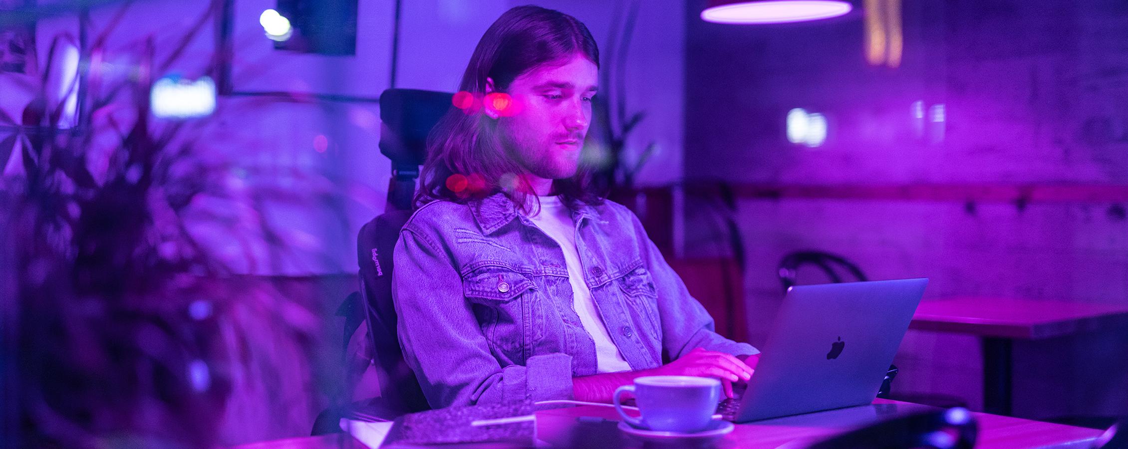 Young man in wheelchair working on laptop for online college class